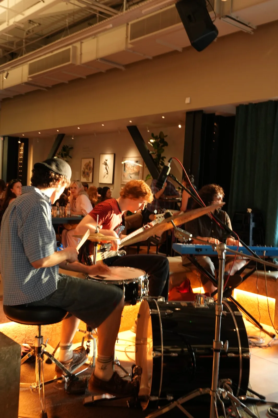 A live trio performing for a seated crowd at Natural Jazz x Voices Radio inside Tate Modern